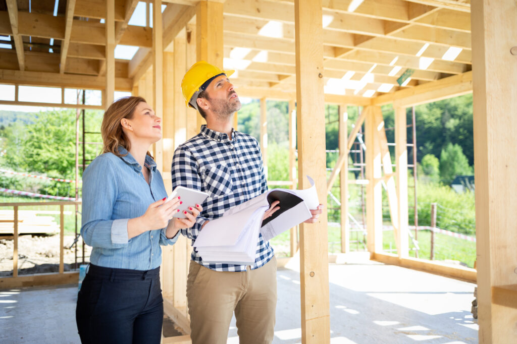 Female homeowner consults blueprints as she examines new home build thanks to RailTrust Mortgage.